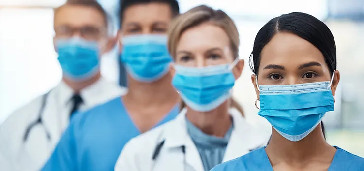 Masked doctors in a queue, the first one prominently visible.